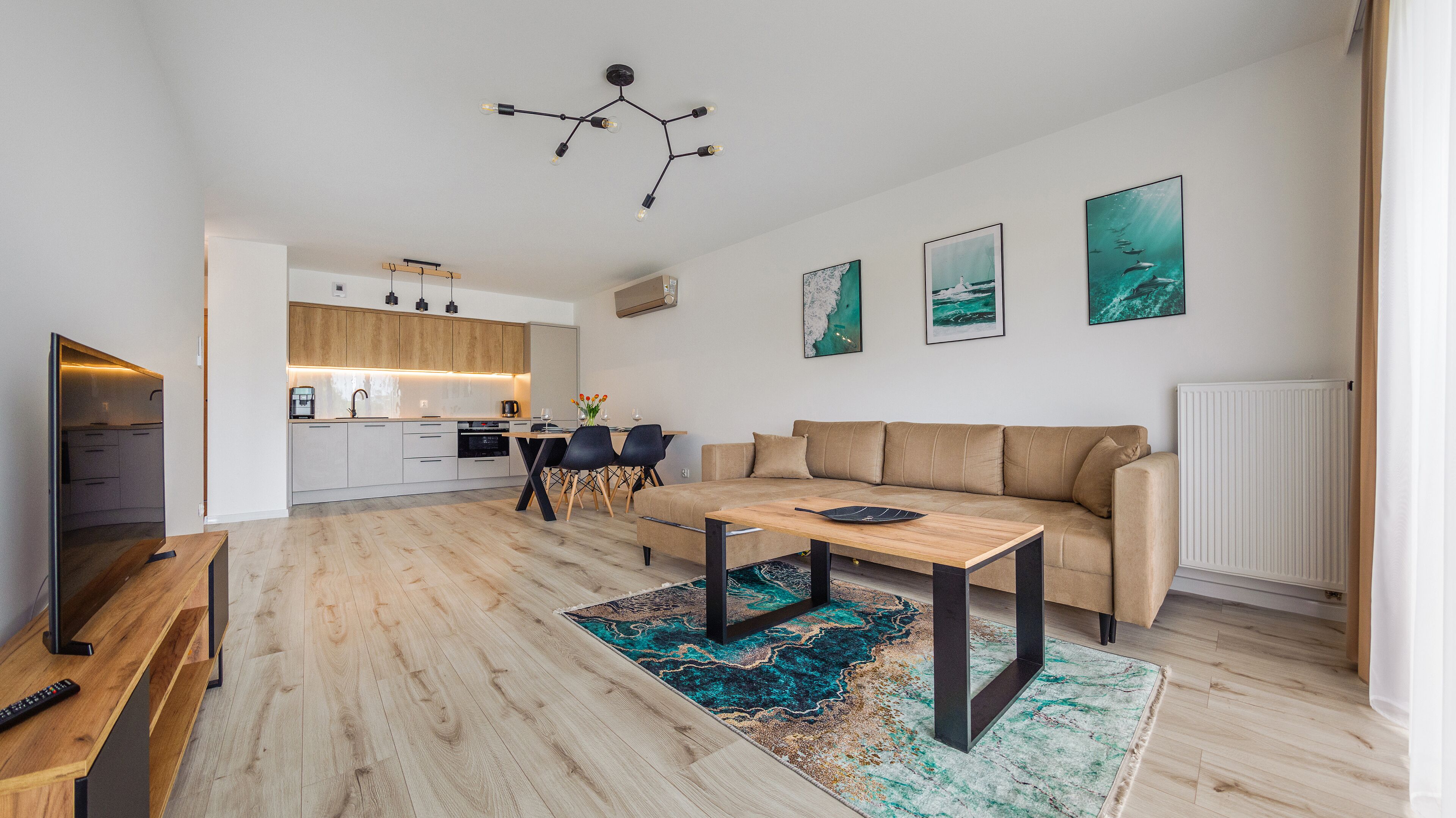 A modern apartment with a kitchen, dining area, and living room.