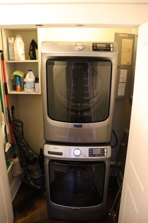 Una sala de bugaderia amb una rentadora i una sequadora Maytag apilades verticalment.