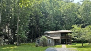 A two-story house with a gravel driveway and a small front porch.