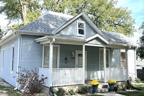Une maison de plain-pied avec un porche à l’avant, une petite fenêtre et une boîte aux lettres.