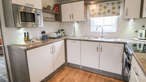 A compact kitchen with a microwave, toaster, sink, and oven. - Bock Retreat (Morpeth)
