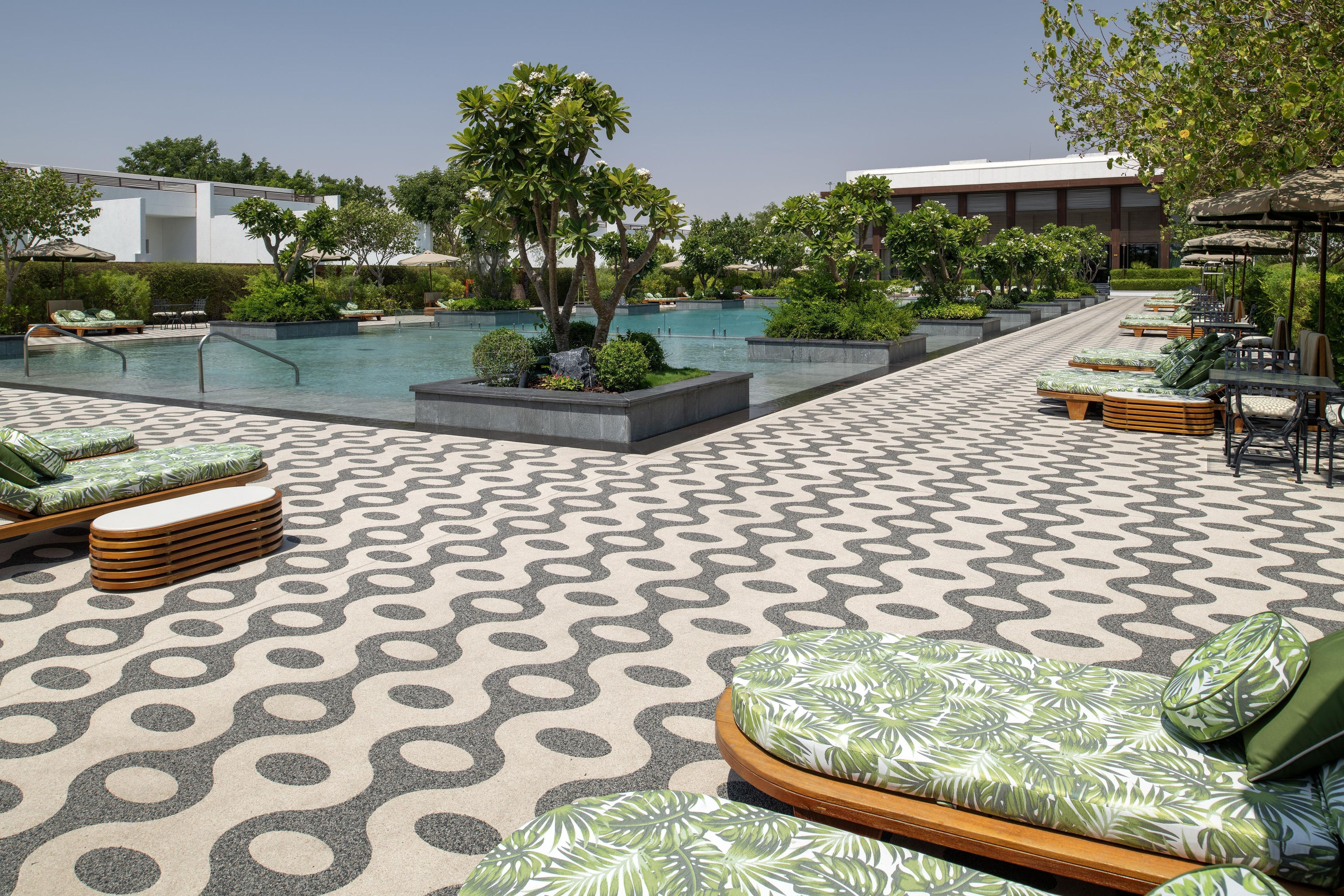A poolside area with lounge chairs and a patterned floor.