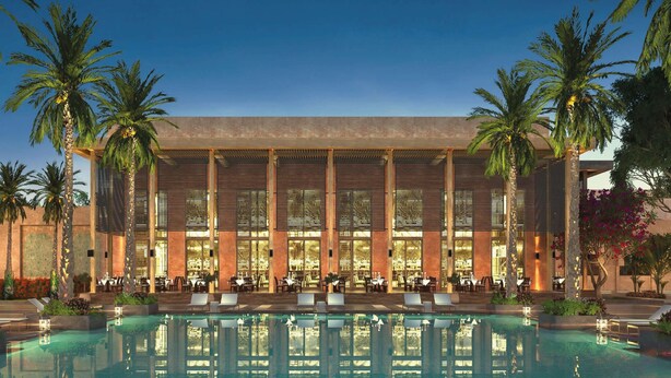 A modern hotel with a large pool, palm trees, and a well-lit facade. - Maysan Doha, LXR Hotels & Resorts (Doha)