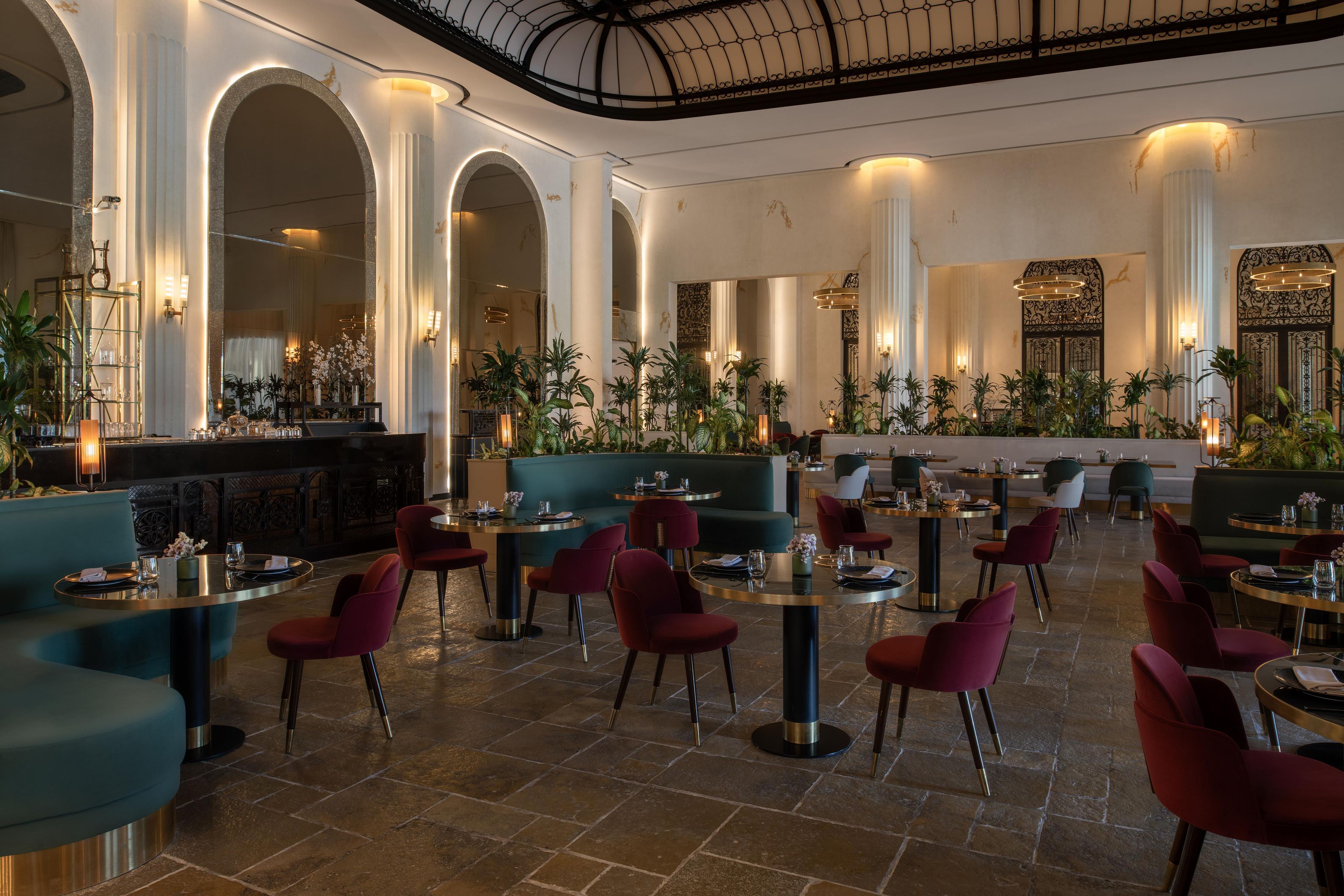 A spacious indoor area with high ceilings, columns, and seating arrangements.