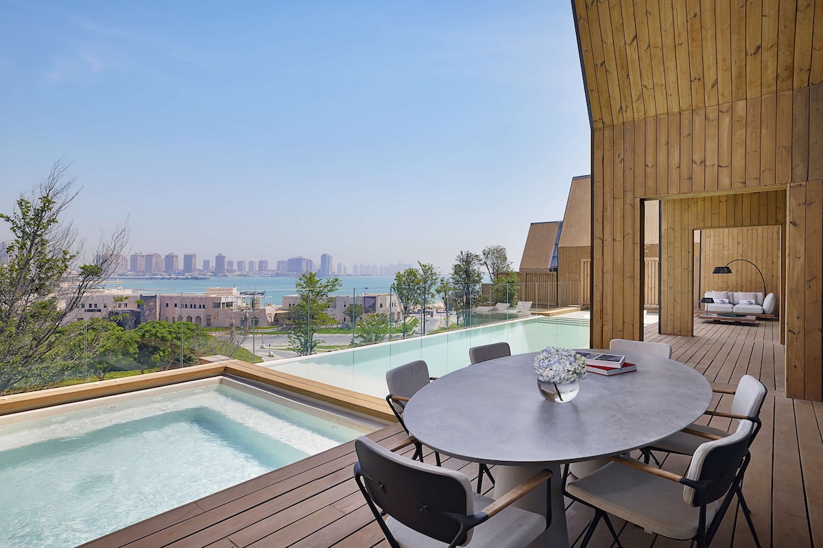 A rooftop terrace with a pool, dining area, and a view of the cityscape.