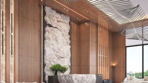 A modern interior with a large rock feature, wooden paneling, and contemporary furniture. - Katara Hills Doha, Lxr Hotels & Resorts (Doha)
