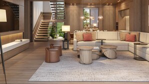 Een moderne woonkamer met een trap, een zithoek en een salontafel.