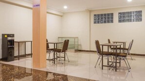 A clean, well-lit indoor space with a marble floor, a water dispenser, and a no-smoking sign on a pillar. - Reddoorz Plus @ Dipatiukur (Bandung)