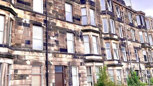 A row of terraced houses with multiple windows and a brick facade.