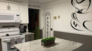 A kitchen with white cabinets, a granite countertop, a coffee maker, and a sign reading "PANTRY". - Cheerful 4BR/12BD “Ravishing Ranch” (Dayton)