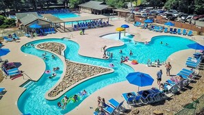Une grande piscine extérieure dotée de plusieurs couloirs de nage et d’un espace distinct pour les toboggans aquatiques.