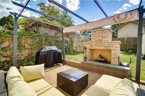 An outdoor patio area with a stone fireplace, a covered seating area, and a grill. - Oakley Square 3BR - Walkable-Sleeps 5 - Fire Pit (Cincinnati)