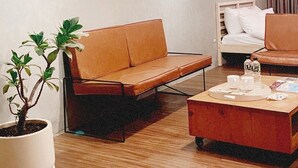 A modern living room with a sofa, a coffee table, and a potted plant. - 開放式廚房，寬敞自由舒適大空間，鄰近孔廟商圈 (Tainan City)