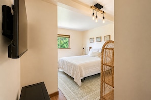 A bedroom with a bed, a bedside table, a lamp, and a window. - Near Fish Lake | Boat Parking | Deck | Dogs | BBQ (Leavenworth)
