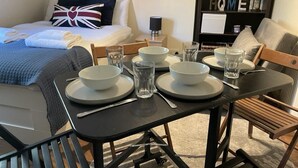 A neatly arranged dining area with a table set for four, including bowls, glasses, and cutlery.