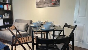 A dining area with a table set for four, surrounded by wooden chairs.