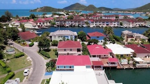 Una zona residencial costera con casas, un puerto deportivo y una carretera que lleva al agua.
