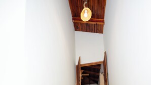Een trap met houten leuningen en een lamp erboven.