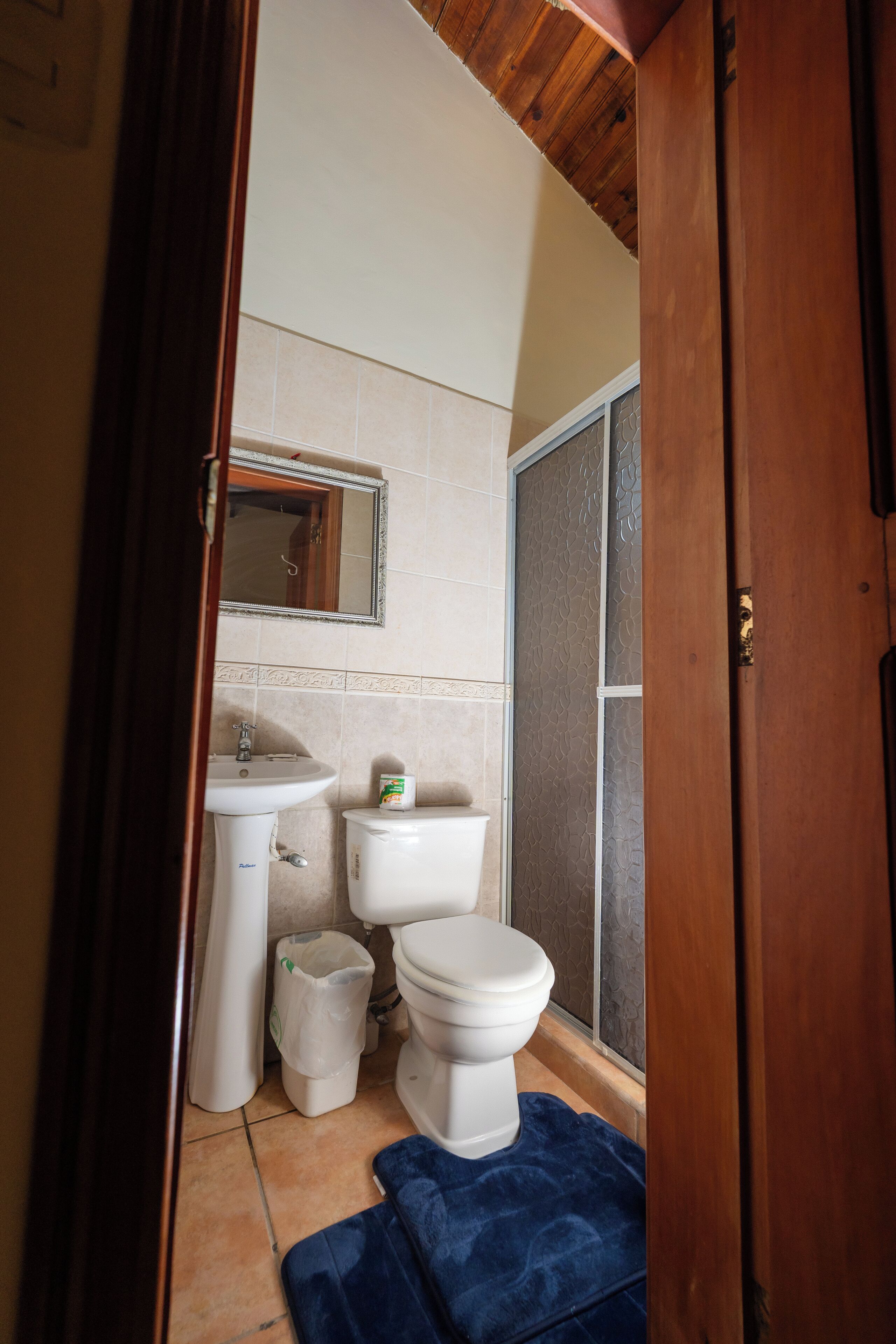 A small bathroom with a toilet, sink, and a mirror.