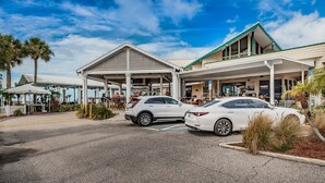 Un hotel con un área exterior techada, un estacionamiento y un edificio con techo verde.
