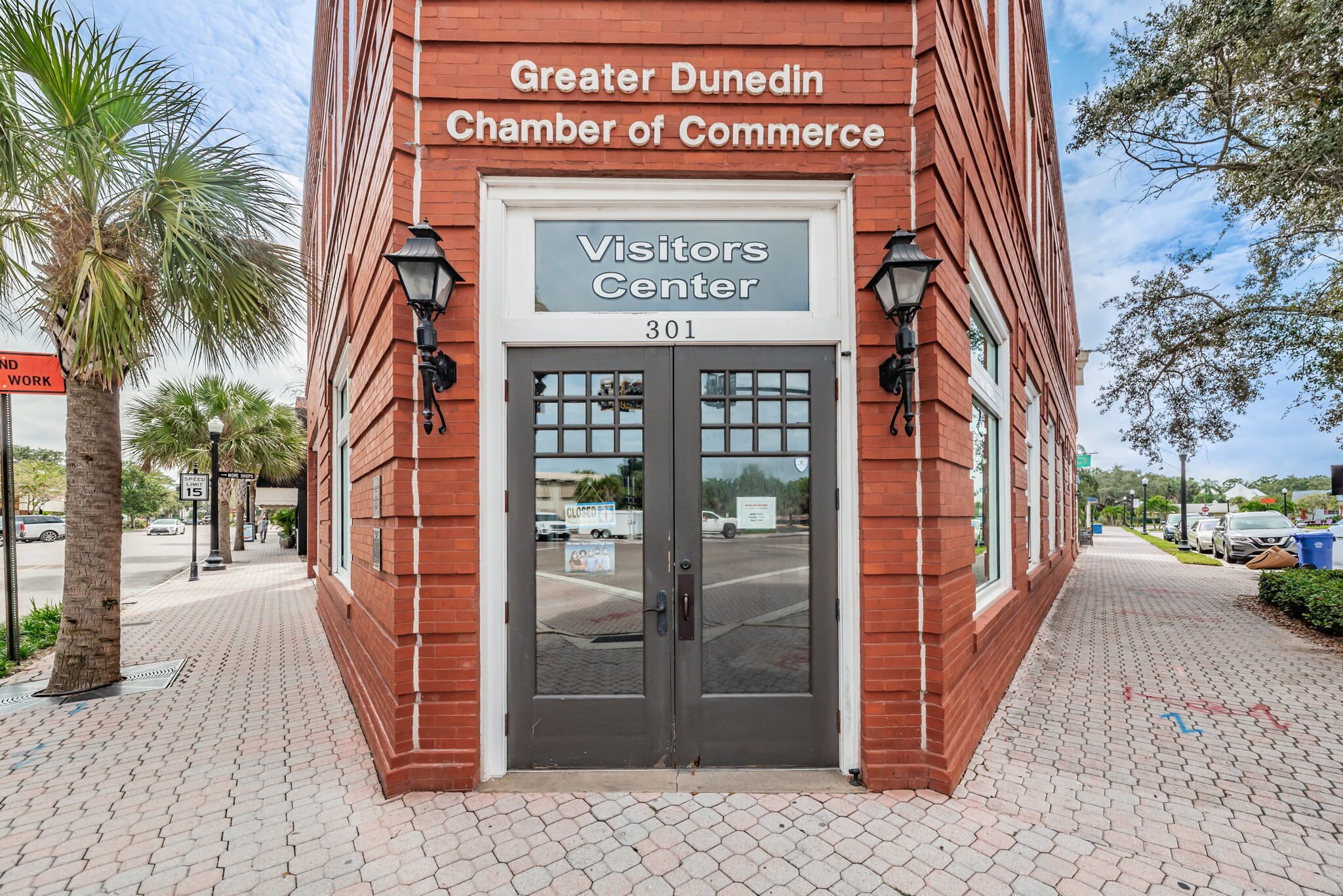 Ein Backsteinhaus mit einem Schild, auf dem steht: Greater Dunedin Chamber of Commerce Visitors Center 301.