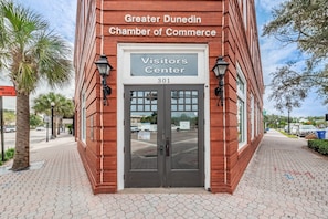 Un bâtiment en briques rouges sur lequel on peut lire l’inscription suivante : « Centre d’information de la Chambre de commerce de la région de Dunedin, 301 ».