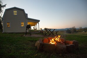 A house with a fire pit in the front yard, a covered patio, and a view of the landscape. - On farm cottage with mountain views. (Bridgewater)