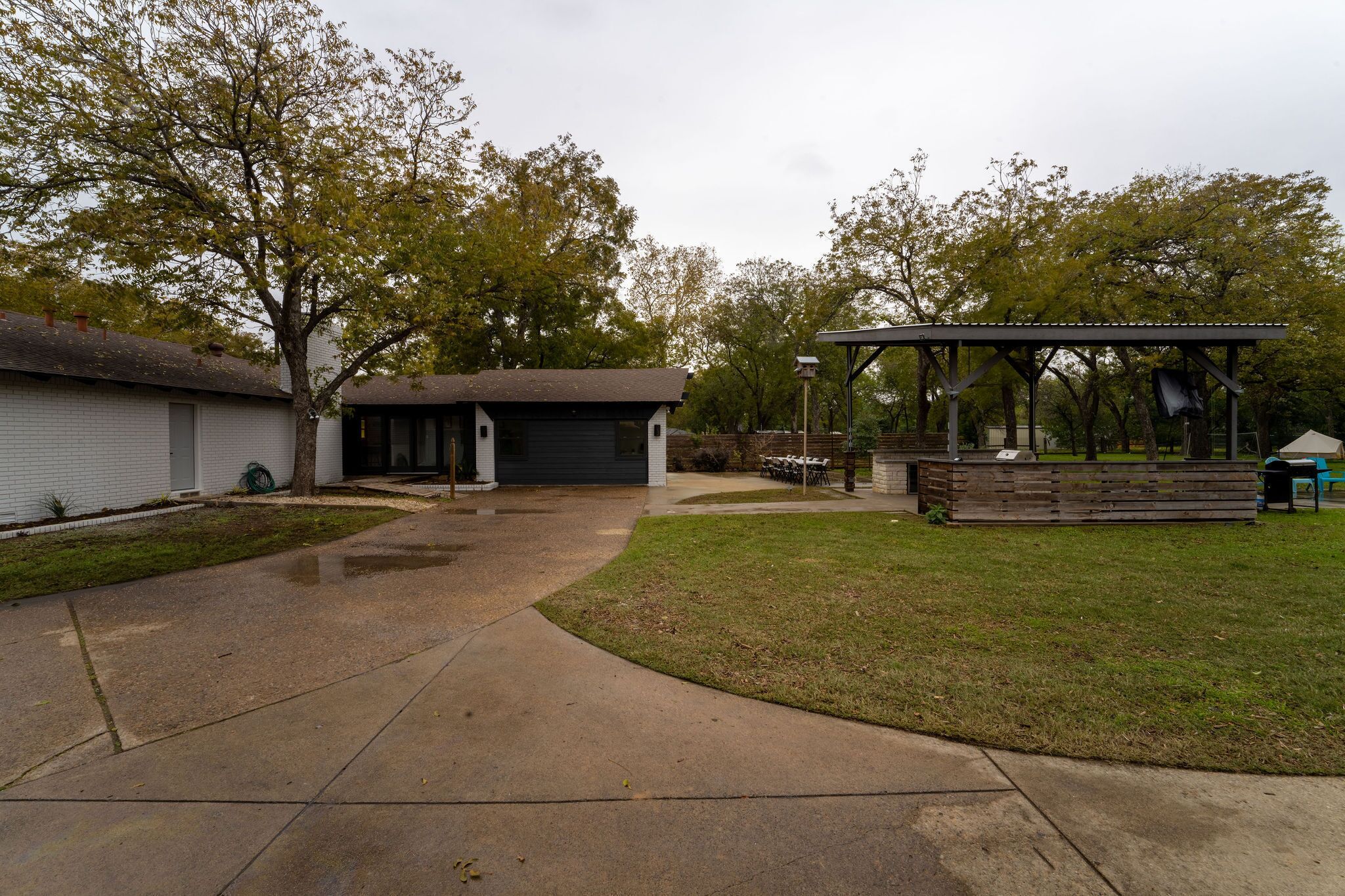 Un espace extérieur abrité doté d’un pavillon, un bâtiment comprenant un garage et une pelouse.