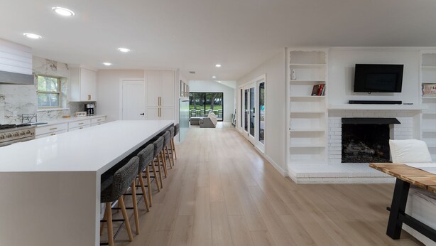 A modern kitchen with a large island, bar stools, a fireplace, and a TV mounted above it. - One of a kind home in the city (Arlington)