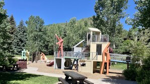 A playground with slides, climbing structures, and picnic tables. - Modern Vail Retreat, Free Shuttle, Fireplace & Mountain Views | SF201 (Vail)