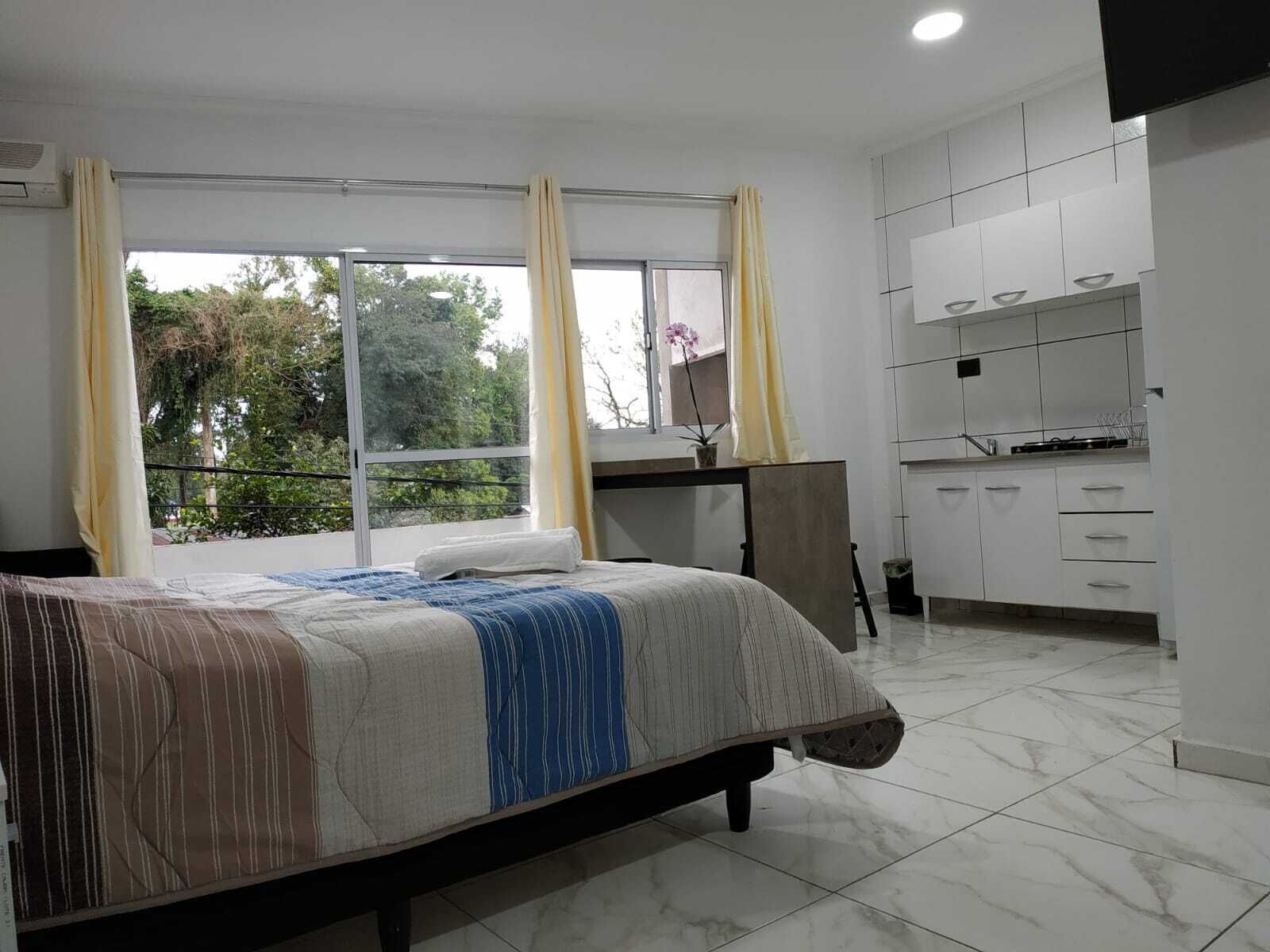 Un dormitorio con cama, escritorio y baño.