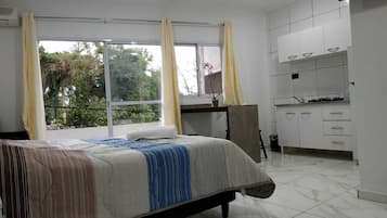 Un dormitorio con cama, escritorio y baño.