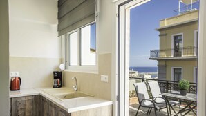 Una cocina con un lavamanos, una cafetera y una ventana.