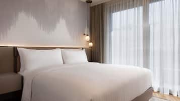 Een groot bed met hoofdeinde, nachtkastje en een wandlamp.