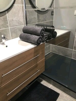 Chuveiro, toalhas de banho, sabonete, shampoo