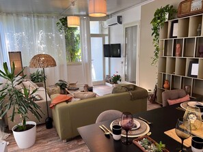 Una sala de estar moderna con un sofá, una mesa de comedor y varias plantas.