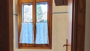 A bathroom with two toilets, a window with curtains, and a towel rack. - Studio apartment on 2 floors "Balzone 1" (Toscana)