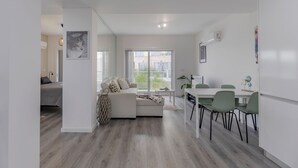 Ein modernes Apartment mit Wohnbereich, Essbereich und Schlafzimmer.