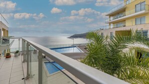 Ein Balkon mit Pool und Blick auf die Küste.
