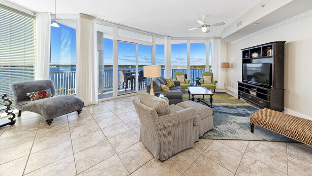 A spacious living room with a balcony, a television, and a seating area.