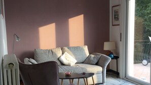 A living room with a sofa, armchair, and a radiator.
