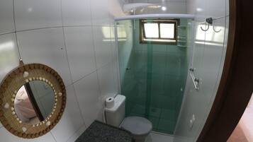 A bathroom with a toilet, sink, and a shower area.