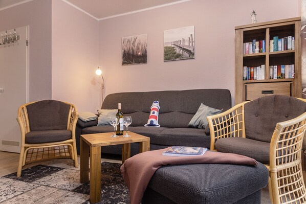 A living room with a sofa, two armchairs, a coffee table, and a bookshelf.