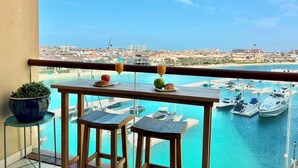 Un balcone con vista su un porto turistico e sullo skyline della città.