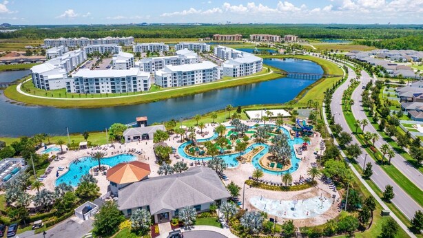 A resort with multiple buildings, a large swimming pool, and a water park.