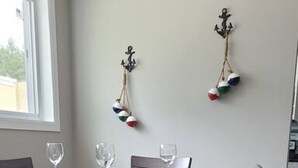 Un coin repas comprenant une table rectangulaire, quatre chaises et deux éléments de décoration fixés au mur.
