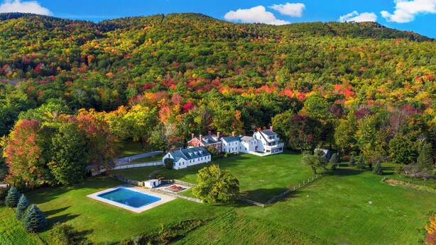 A large estate with multiple buildings, a swimming pool, and a well-maintained lawn.