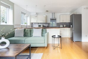 Relax in this serene living space with a sofa and table overlooking lush greenery.