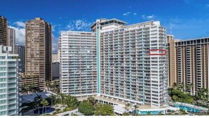 Um hotel moderno com vários andares, um átrio central e área de piscina.