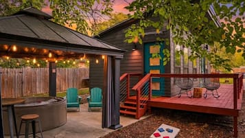 Ein Garten mit Whirlpool, Sitzgelegenheiten im Freien und einer Terrasse.